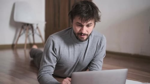 Man Paying Bills Online at Home Using Laptop and Documents Financial Management Remote Payment