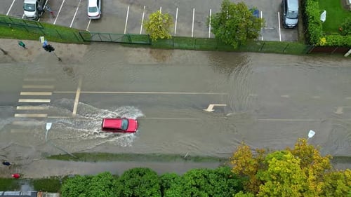 Flooded Street with a Car Driving Through Water