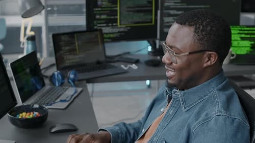 Black Man Having Video Conference on Computer while Program Coding in Office