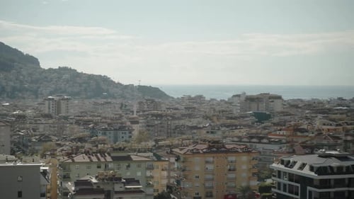 View from a high point on the roofs of houses in a coastal town with the sea in the background.