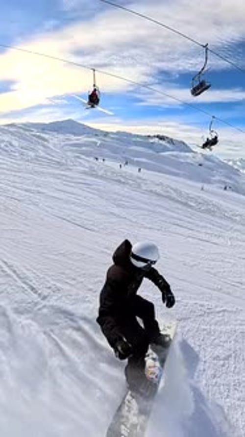 Snowboarder, der einen verschneiten Berghang hinunterflitzt