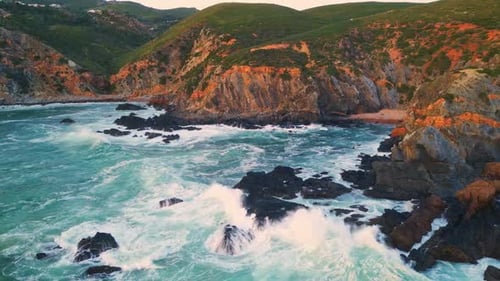 Breathtaking Coastal View of Turquoise Waves Crashing Against Rugged Cliffs