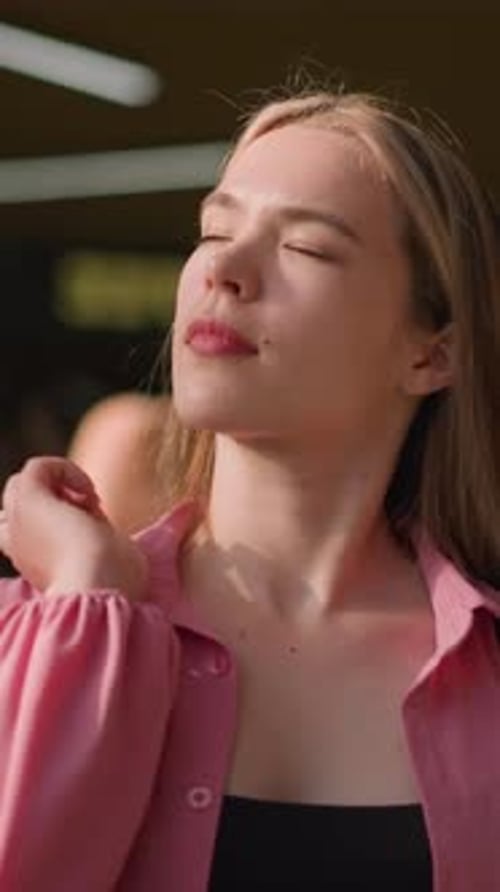 Dame en rose souriant et tenant un sac avec fond flou dans une lumière douce