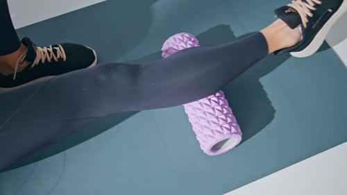 Closeup Leg Massaging Foam Roller Training Muscles in Private Gym at Carpet