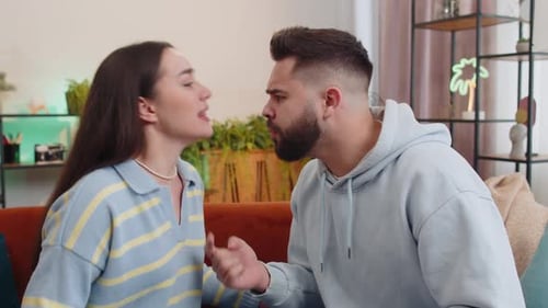 Young Couple Arguing on a Couch Indoors
