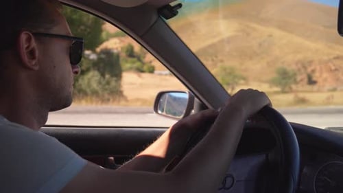 Man driving car side view inside cabin