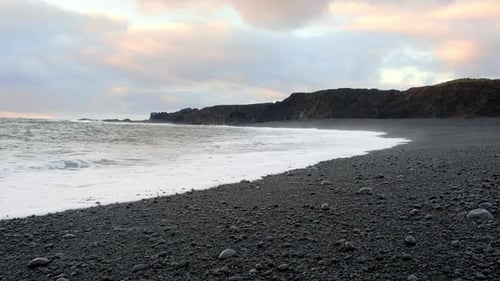 Icelandic Black Sand Beach Coast at Sunset Volcanic Cliffside with Blue North Atlantic Ocean Water