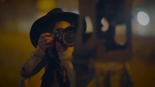 Stylish Brunette Woman Holding Camera at Night