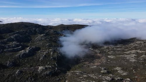 Aerial view of a magical valley filled with clouds. Going backward and away from the clouds. Unique
