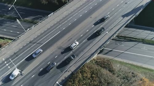 Aerial Drone Footage Flying Above an Urban Bridge Intersection with Moderate Car Traffic. Sunny Day