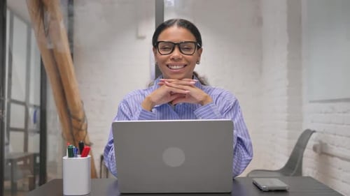 Woman Smiling at Laptop at Desk