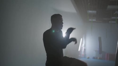 Kaukasischer Mann-Kämpfer trainiert seine Schläge und Verteidigung im Boxstudio Professionelle Kickboxer-Züge
