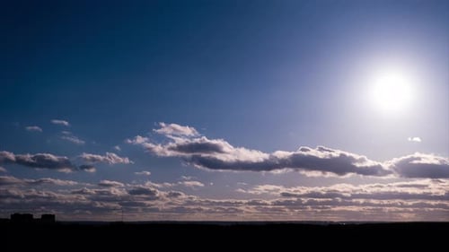 Zeitraffer von sich am Himmel bewegenden Cumuluswolken mit Sonne über dem Horizont
