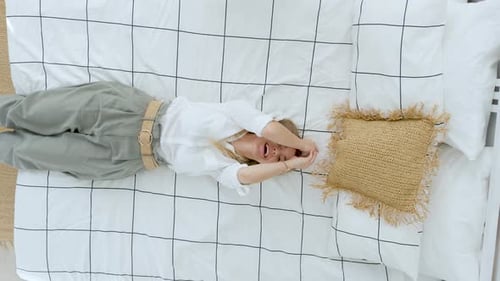 happy woman lies on the bed, top view