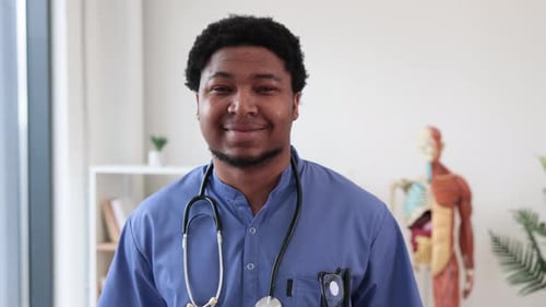 Surgeon in Scrubs and with Stethoscope Standing in Office