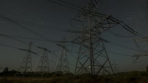 Nighttime View of Power Lines Against a Starry Sky in a Remote Area with Clear Visibility of