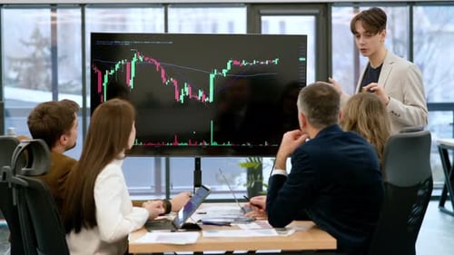 Young worker leading business meeting in an office, discussing the topic of cryptocurrencies with ot