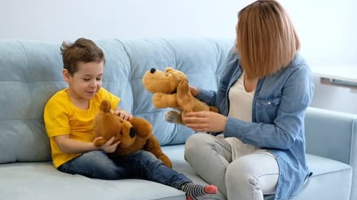 Woman and Child Play with Stuffed Animals Indoors