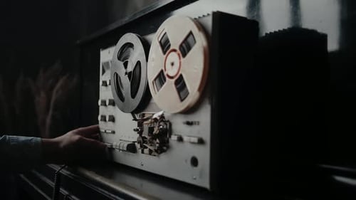 Man Pressing Button on Vintage Reel-to-Reel Recorder