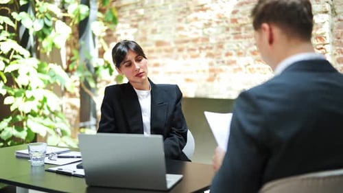 Business Meeting Businesswoman and Businessman Discussing Contract in Modern Office
