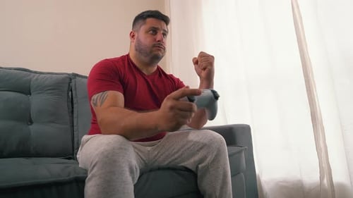 Man Playing Video Game on Couch at Home