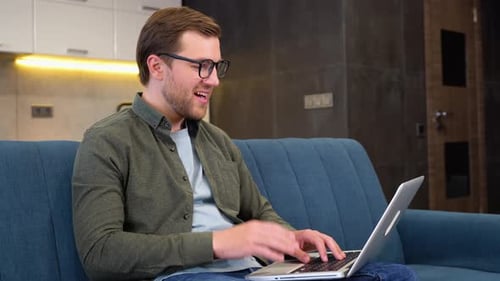 Young Man Video Calling on Laptop at Home