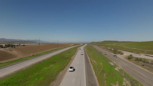 Vorwärter fliegen über mehrere Straßen und Eisenbahnen in ländlichen Landschaften Fahrzeuge, die auf Transportmitteln fahren