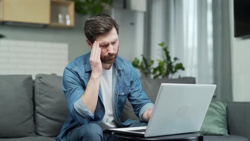Man Typing on Laptop Develops a Headache
