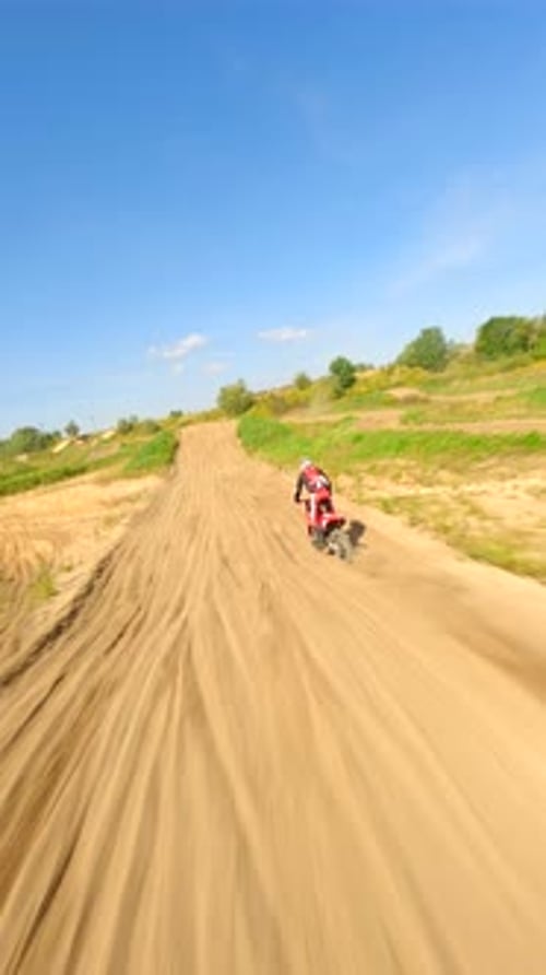 Motocross Rider Speeding on Dirt Track on Sunny Day