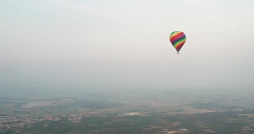 Aerial shot of colorful hot air balloon is flying on a scenic panoramic view in the sky on a sunny