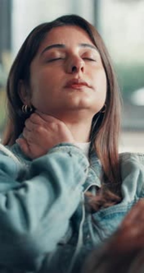 Woman Massaging Her Neck for Pain Relief Indoors