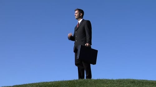 Businessman in suit enjoys a tranquil walk through a lush green park