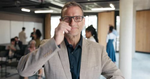 Smiling Man Wearing Glasses in Corporate Office Setting