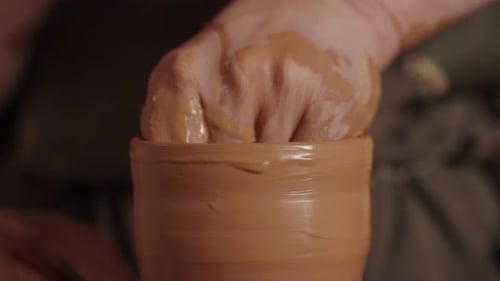 Hands Shaping Clay on Pottery Wheel Close Up