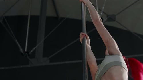 Athletic Woman Pole Dancing in Urban Studio