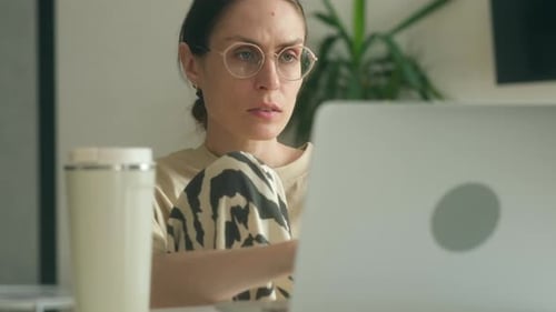 Woman Works at Laptop at Home During Daytime