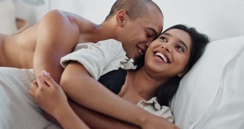 Happy Couple Embracing in Bed Together