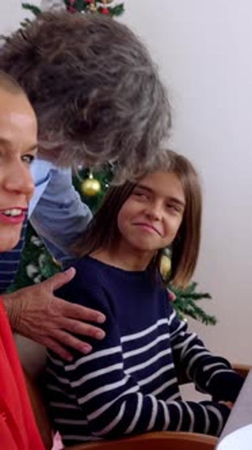 Family Laughing by Christmas Tree in Home