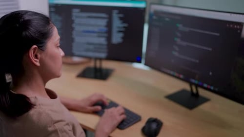 Close-up of IT woman working on desktop computer in data center control room Young professionals