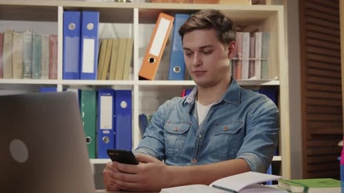 Company Employee Using Modern Smartphone on Break in the Office Portrait of Young Man Messaging in