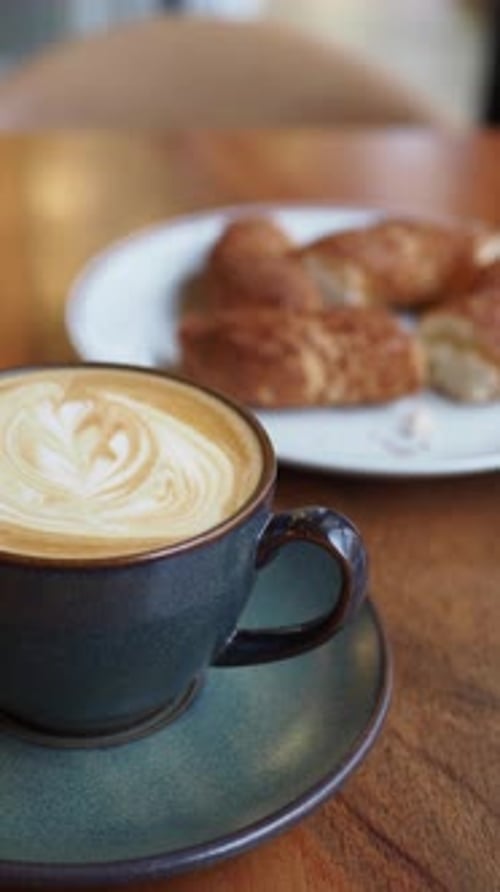 A Delightfully Delicious Coffee Accompanied By a Freshly Baked Croissant on a Cafe Table