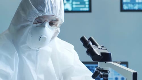 Scientist Examines Sample through Microscope in Bright Lab