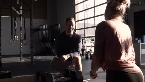 Smiling Personal Trainer Talking With Client In Gym Slow Motion