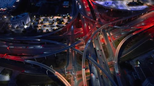 Multiple vehicles ride by the stunning huge road interchange.