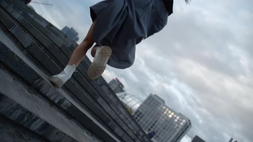 Energetic Woman Running Stairs While Walking At Evening City Modern Buildings. Back View Young Fe...