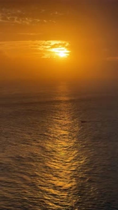 Golden Sunset Against the Background of Passing Boats in the Ocean