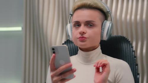 Caucasian Woman Girl in Headphones Choose Music Online Playlist Listen Song Mobile Phone Smartphone