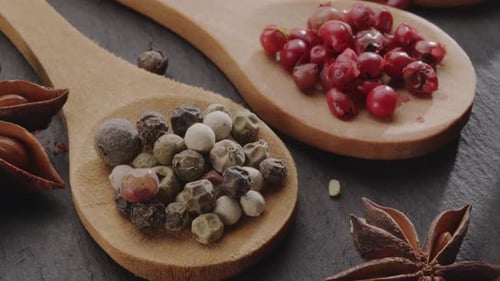 Various types of spices on wooden spoons close up.