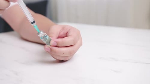 Mann, der eine Ampulle mit Absaugimpfung durchführt. COVID-19-Präventionskonzept.