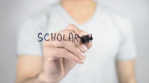 Writing Scholarship with Marker on Clear Surface